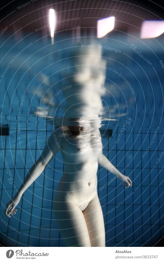 Underwater body portrait with reflection at the waterline of a