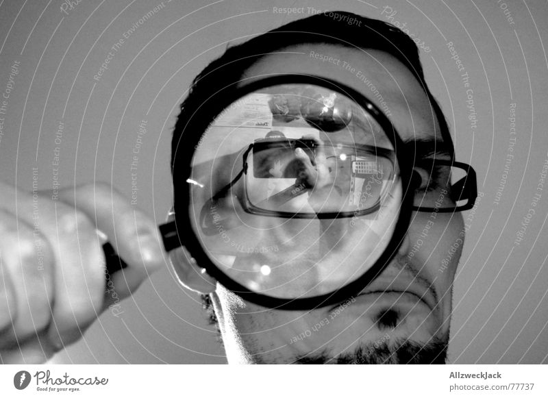 black man looking through magnifying glass