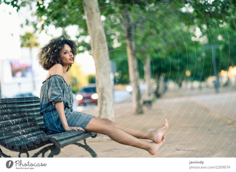 Black Woman With Afro Hairstyle Sittin On A Urban Bench - A Royalty ...