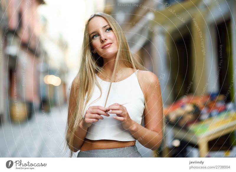 Beautiful young caucasian woman in urban background. Blond girl