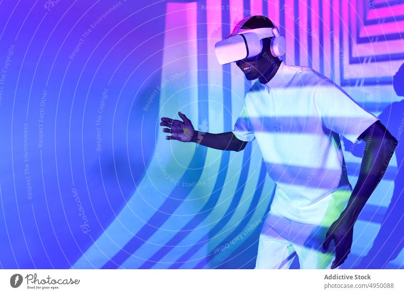 Black man looking at imaginary object while exploring cyberspace in glasses - a Royalty Free Photo from Photocase