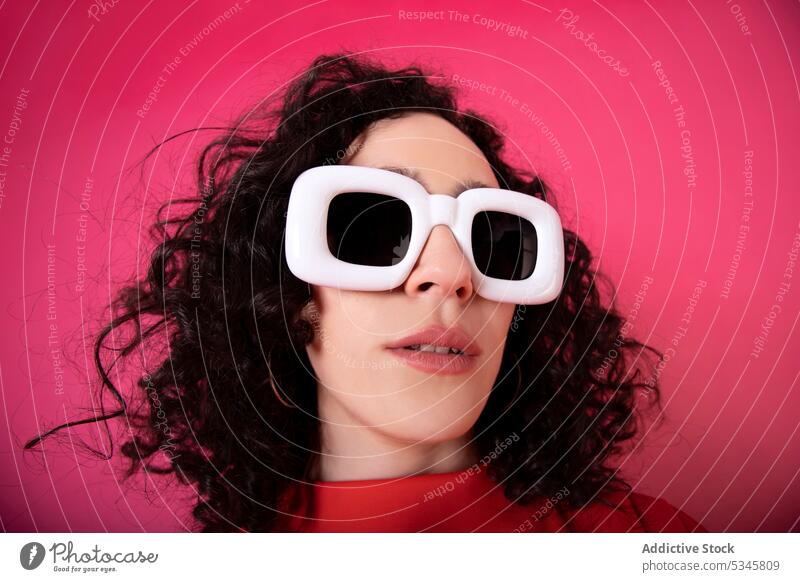 Woman in trendy sunglasses on pink background - a Royalty Free Stock