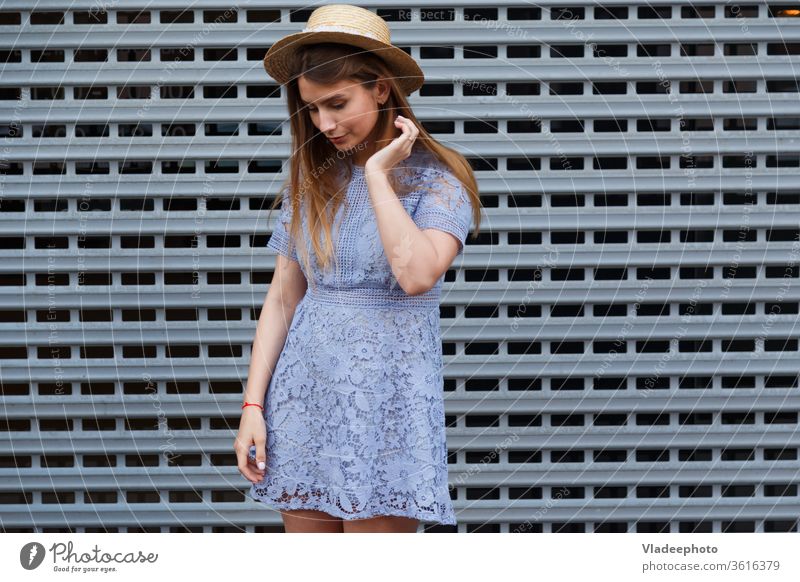 Portrait of a beautiful graceful woman in elegant hat and blue