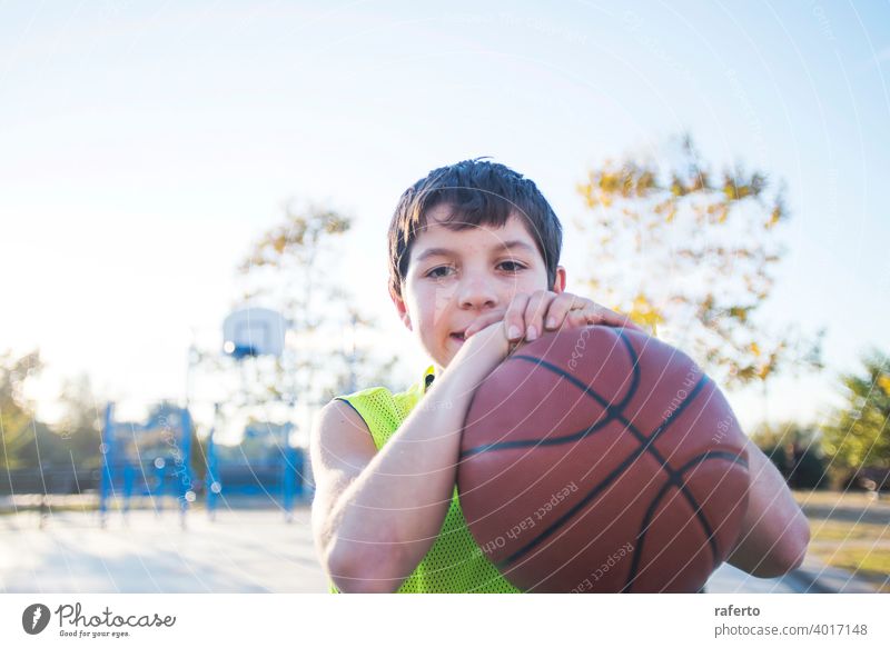 A man in a basketball uniform standing on a street photo – Free