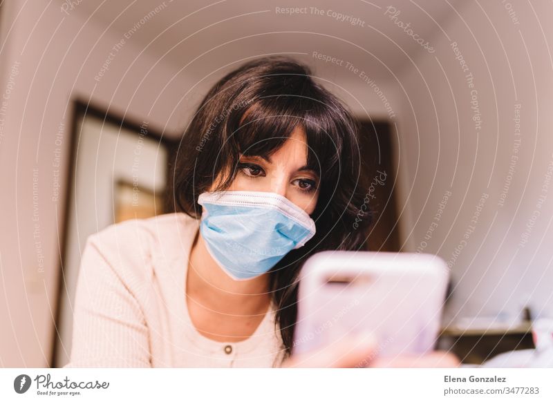 A Woman Using A Smartphone Wears A Medical Face Mask To Avoid The