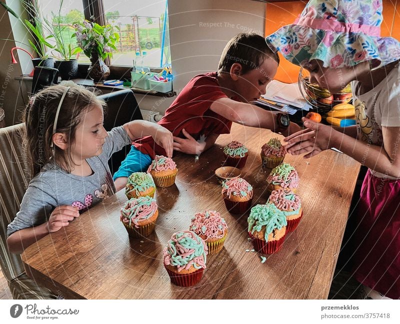 Children baking cupcakes, preparing ingredients, decorating cookies - a  Royalty Free Stock Photo from Photocase